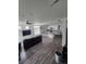 Open-concept living area featuring laminate flooring, ceiling fan, and a large island with barstool seating at 18006 E 103 Ave, Commerce City, CO 80022