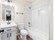 Bright bathroom features tiled shower-tub, updated vanity with modern fixtures, and wood-look floors at 5470 Krameria St, Commerce City, CO 80022