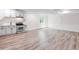Bright open kitchen features stainless appliances and updated cabinets in a spacious living area with luxury vinyl plank flooring at 5470 Krameria St, Commerce City, CO 80022