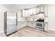 Basement kitchen features modern appliances, white cabinets, and wood floors at 5470 Krameria St, Commerce City, CO 80022
