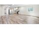 Bright open kitchen features stainless appliances and updated cabinets in a spacious living area with luxury vinyl plank flooring at 5470 Krameria St, Commerce City, CO 80022