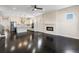 Open-concept living area featuring dark hardwood floors, a modern fireplace, and a seamless connection to the kitchen at 5470 Krameria St, Commerce City, CO 80022