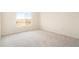 Neutral carpeted bedroom features an exterior view, a window for natural light, and white walls at 905 S Zeno Way # 204, Aurora, CO 80017