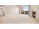 Bright living room with fireplace, plush carpet, and sliding doors to the balcony at 905 S Zeno Way # 204, Aurora, CO 80017