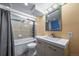 Modern bathroom featuring a bathtub, shower, decorative mirror, and vanity sink with stylish fixtures at 9231 W Louisiana Ave, Lakewood, CO 80232