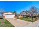 Exterior view showing a single story house with a 2 car garage, sidewalk and green lawn at 9231 W Louisiana Ave, Lakewood, CO 80232