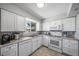 Bright kitchen with white cabinetry, granite countertops, and tiled floors at 9231 W Louisiana Ave, Lakewood, CO 80232