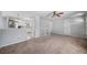 Open-concept living room featuring plush carpet, light walls, ceiling fan, and access to the kitchen at 9231 W Louisiana Ave, Lakewood, CO 80232