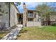 Charming exterior view of a multi-level condo with a stone chimney and well-maintained lawn at 7720 W 87Th Dr # J, Arvada, CO 80005