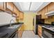 Functional kitchen with stainless steel refrigerator, ample cabinet space, and black countertops at 7720 W 87Th Dr # J, Arvada, CO 80005