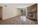 Living room featuring wood floors, sliding glass doors to the patio, and a stone fireplace at 7720 W 87Th Dr # J, Arvada, CO 80005