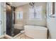A modern bathroom with a soaking tub, glass enclosed shower, and decorative light fixture at 268 Simmental Loop, Castle Rock, CO 80104