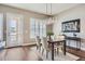 Dining area featuring a modern chandelier, wood table, neutral walls and sliding glass doors at 268 Simmental Loop, Castle Rock, CO 80104