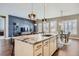 Open kitchen featuring a large island, modern pendant lights, and seamless flow to living spaces at 268 Simmental Loop, Castle Rock, CO 80104