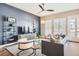 Comfortable living room featuring a ceiling fan, modern decor, and large windows with shutters at 268 Simmental Loop, Castle Rock, CO 80104