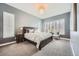 A serene main bedroom with neutral tones, large windows with shutters, and elegant chandelier lighting at 268 Simmental Loop, Castle Rock, CO 80104