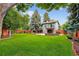 Expansive backyard with a well-maintained lawn and patio, framed by mature trees and a wooden fence at 6338 S Oneida Ct, Centennial, CO 80111