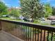 A view from a balcony featuring a landscaped area and a residential street with mature trees and parked cars at 2802 Sundown Ln # 103, Boulder, CO 80303