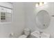 Clean powder room featuring a round mirror and classic fixtures at 23820 E 34Th Ave, Aurora, CO 80019