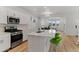 Well-lit kitchen with stainless steel appliances, white cabinets, a spacious island, and wood floors at 23820 E 34Th Ave, Aurora, CO 80019