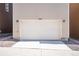 Beige garage door with house number above and flanked by sconces, with gravel landscaping and concrete driveway at 11918 Mountview Ln, Broomfield, CO 80021