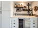 Stylish bar area with custom cabinets, shelving, a wine refrigerator, and elegant decor at 8862 Chestnut Hill Ln, Highlands Ranch, CO 80130
