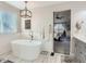 Bright bathroom with a soaking tub next to a window and views into the main bedroom at 8862 Chestnut Hill Ln, Highlands Ranch, CO 80130