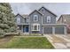 Charming two-story home with a manicured lawn, blue accents, and a spacious two-car garage at 8862 Chestnut Hill Ln, Highlands Ranch, CO 80130