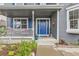 Inviting front porch with a vibrant blue door, white railing, and decorative flower pots and greenery at 8862 Chestnut Hill Ln, Highlands Ranch, CO 80130