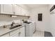 This laundry room features bright white cabinets, modern appliances, and a grey countertop at 8862 Chestnut Hill Ln, Highlands Ranch, CO 80130