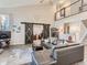 Open-concept living room boasts soaring ceilings, barn doors, a loft area, and modern decor at 8862 Chestnut Hill Ln, Highlands Ranch, CO 80130