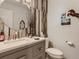Stylish powder room with a modern vanity, round mirror, and decorative wall accents at 8862 Chestnut Hill Ln, Highlands Ranch, CO 80130
