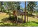 Backyard features a charming treehouse with ladder and play area, nestled amongst mature trees at 33208 Alta Vista Dr, Evergreen, CO 80439