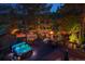 Backyard deck featuring a hot tub, string lights, tennis court and outdoor fire pit seating area at 33208 Alta Vista Dr, Evergreen, CO 80439