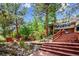Multi-tiered backyard with lush landscaping, wood decks, and mature trees at 33208 Alta Vista Dr, Evergreen, CO 80439