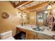 Stylish half bathroom features a copper sink, decorative ceiling and stone tile floor at 33208 Alta Vista Dr, Evergreen, CO 80439
