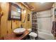 Rustic bathroom with wood paneling, stone sink, and decorative mirror create a unique, charming space at 33208 Alta Vista Dr, Evergreen, CO 80439