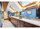 A bathroom with a long double vanity, a blue wall, a skylight and decorative lighting at 33208 Alta Vista Dr, Evergreen, CO 80439
