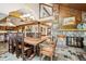 Spacious dining room featuring a stone accent wall, wood ceiling beams, slate floors, and a rustic-style table at 33208 Alta Vista Dr, Evergreen, CO 80439