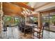 Dining room with stone flooring, a wood beam ceiling, a chandelier, and sliding doors to the deck at 33208 Alta Vista Dr, Evergreen, CO 80439