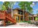 View of the home's exterior showcasing stone accents, wooden pergola, and well-manicured landscaping at 33208 Alta Vista Dr, Evergreen, CO 80439