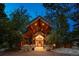 Unique home entrance featuring antlers above the covered stone entryway with wood beam construction and front door at 33208 Alta Vista Dr, Evergreen, CO 80439