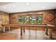 Spacious game room with unique log table, stone accent wall and outdoor views at 33208 Alta Vista Dr, Evergreen, CO 80439