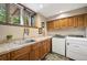 Laundry room features tile counters, wood cabinets, and modern washer/dryer at 33208 Alta Vista Dr, Evergreen, CO 80439