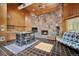 Open living room features a stone fireplace and kitchenette, creating a cozy and functional space at 33208 Alta Vista Dr, Evergreen, CO 80439