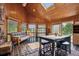 Sunroom with tile flooring and many windows providing natural light. Also features a table and seating area at 33208 Alta Vista Dr, Evergreen, CO 80439