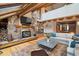 Living room boasts stone fireplace, wood beams, hardwood floors, and plenty of natural light from the skylights at 33208 Alta Vista Dr, Evergreen, CO 80439