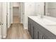 Modern double vanity bathroom with gray cabinets and white countertops at 6050 Hourglass Dr, Brighton, CO 80601