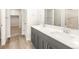 Double vanity bathroom with gray cabinets and quartz countertops at 6050 Hourglass Dr, Brighton, CO 80601