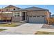 Beautiful single-Gathering home with stone accents, a gray roof, attached two-car garage, and newly installed front yard at 6050 Hourglass Dr, Brighton, CO 80601